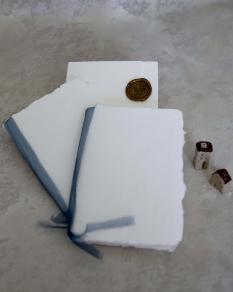 handmade paper wedding vows booklet with white cover and navy blue hand-dyed natural silk ribbons